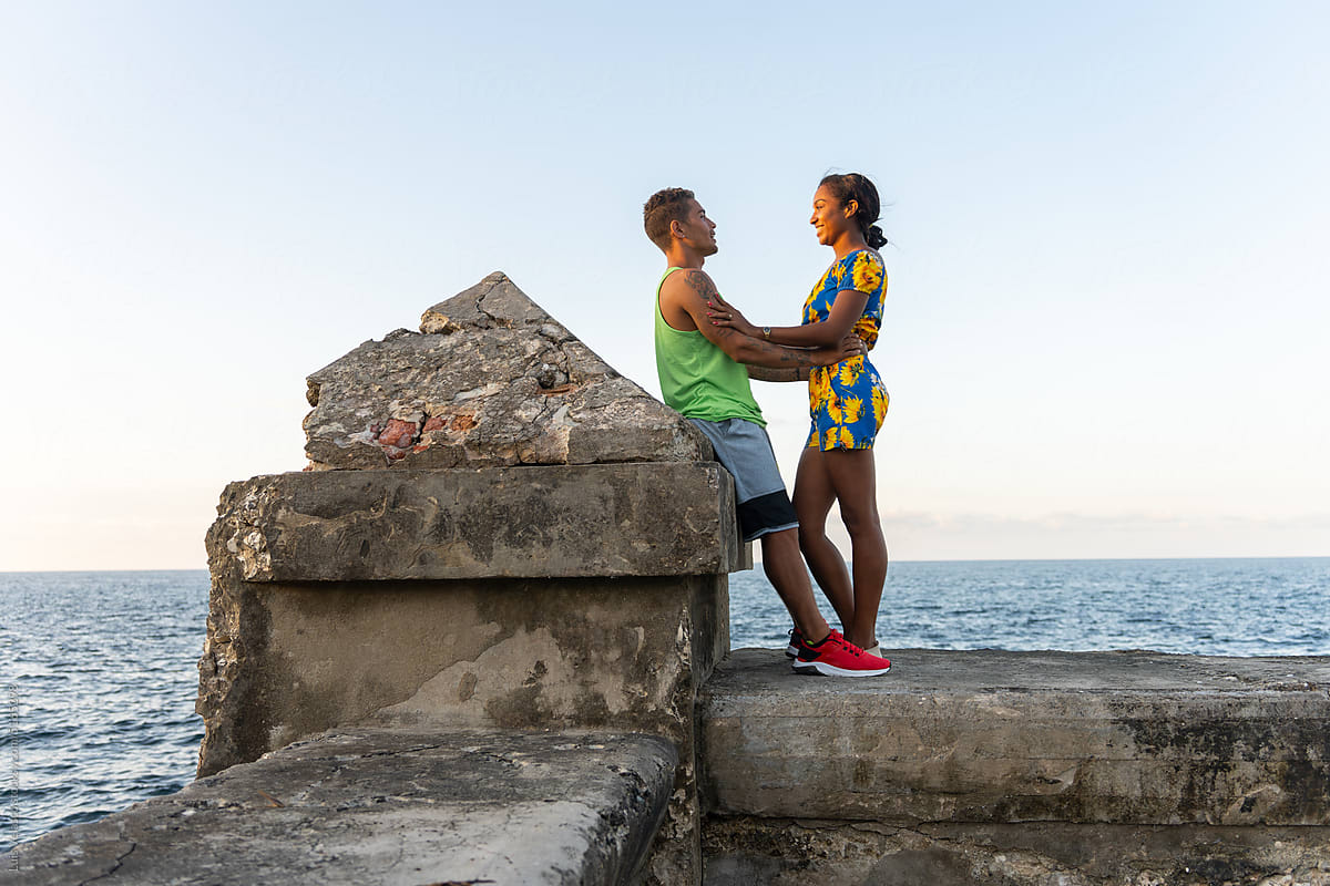 Young Cuban Couple Talking And Hugging Near The Sea.