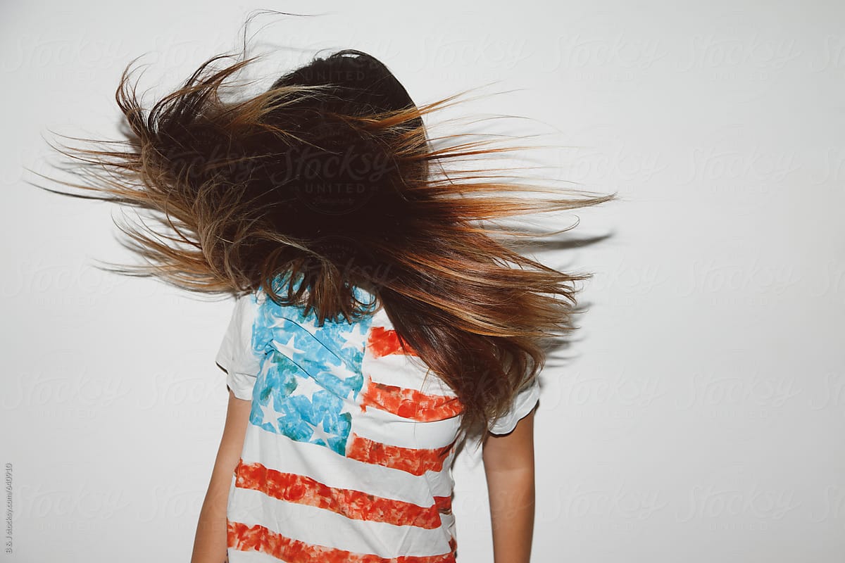 Young girl in Stars and Stripes t-shirt, long hair don\'t care.