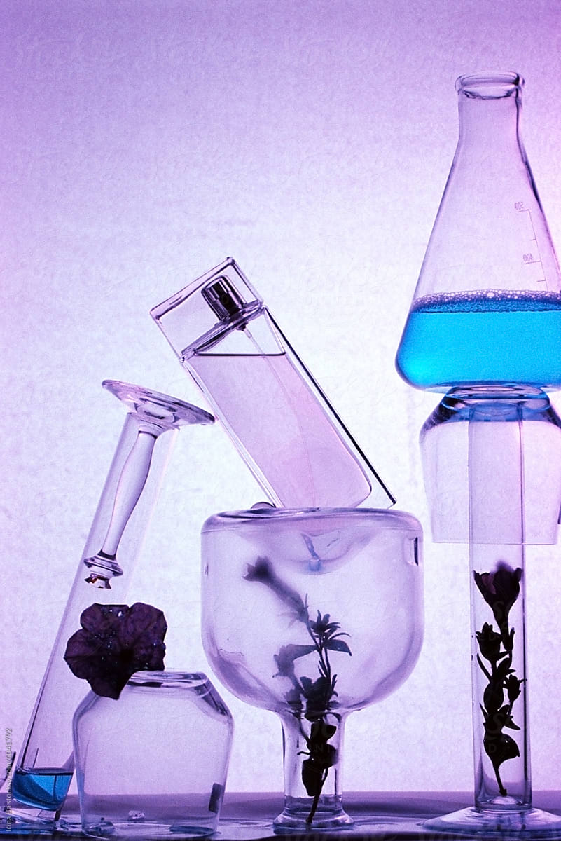 perfume with scientific glassware on purple background