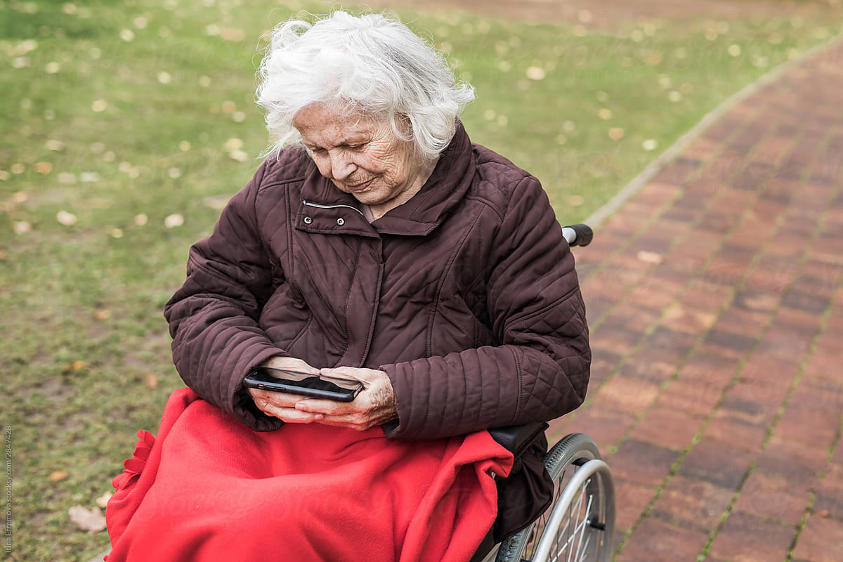 Old woman enjoys music video on a smartphone