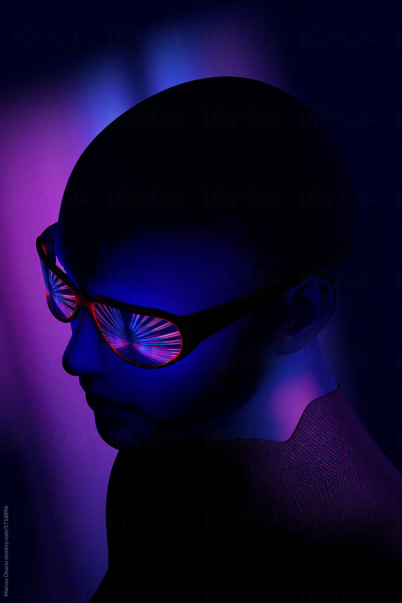 A woman with dark skin and sunglasses in a dark room