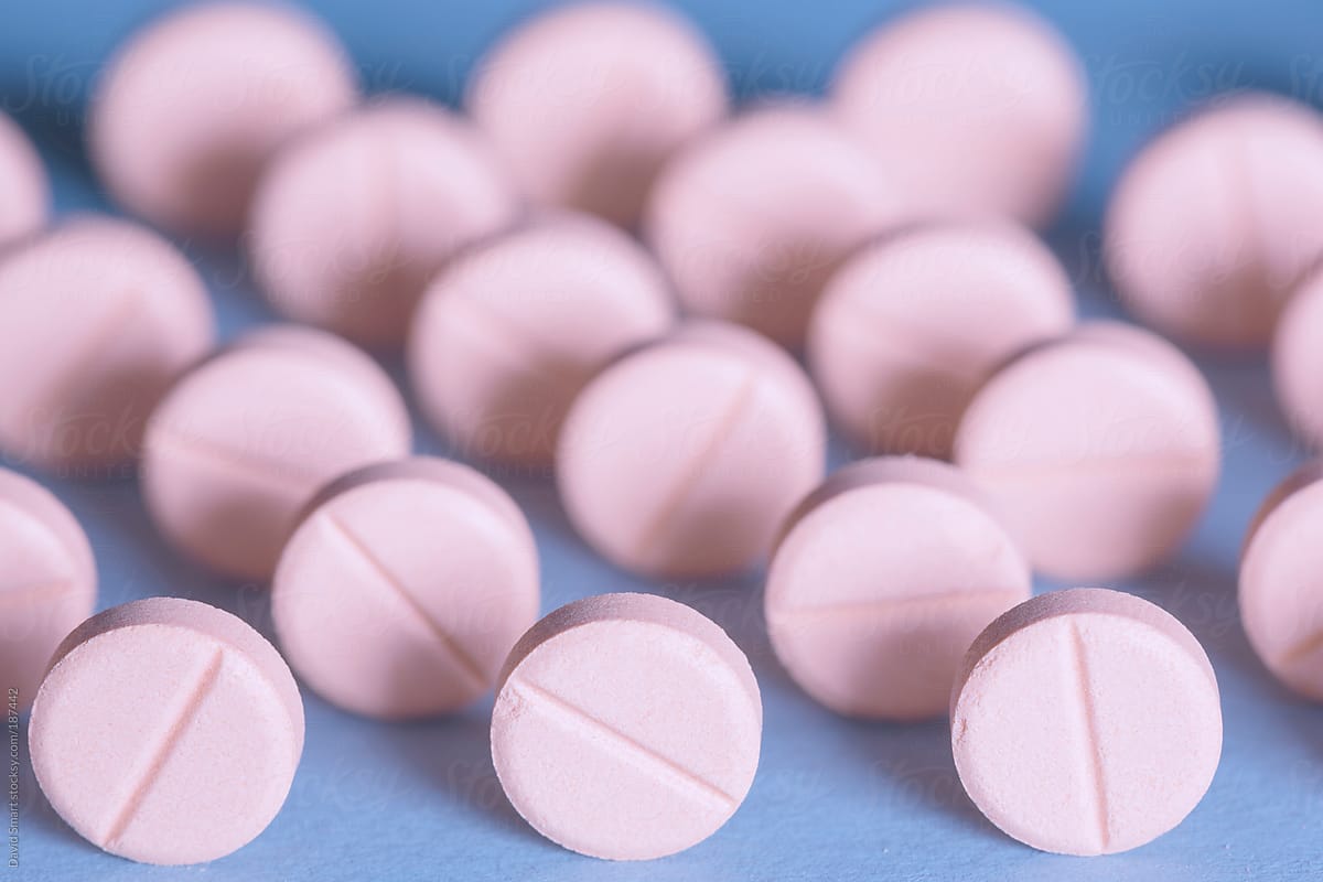 Pink pills on blue background