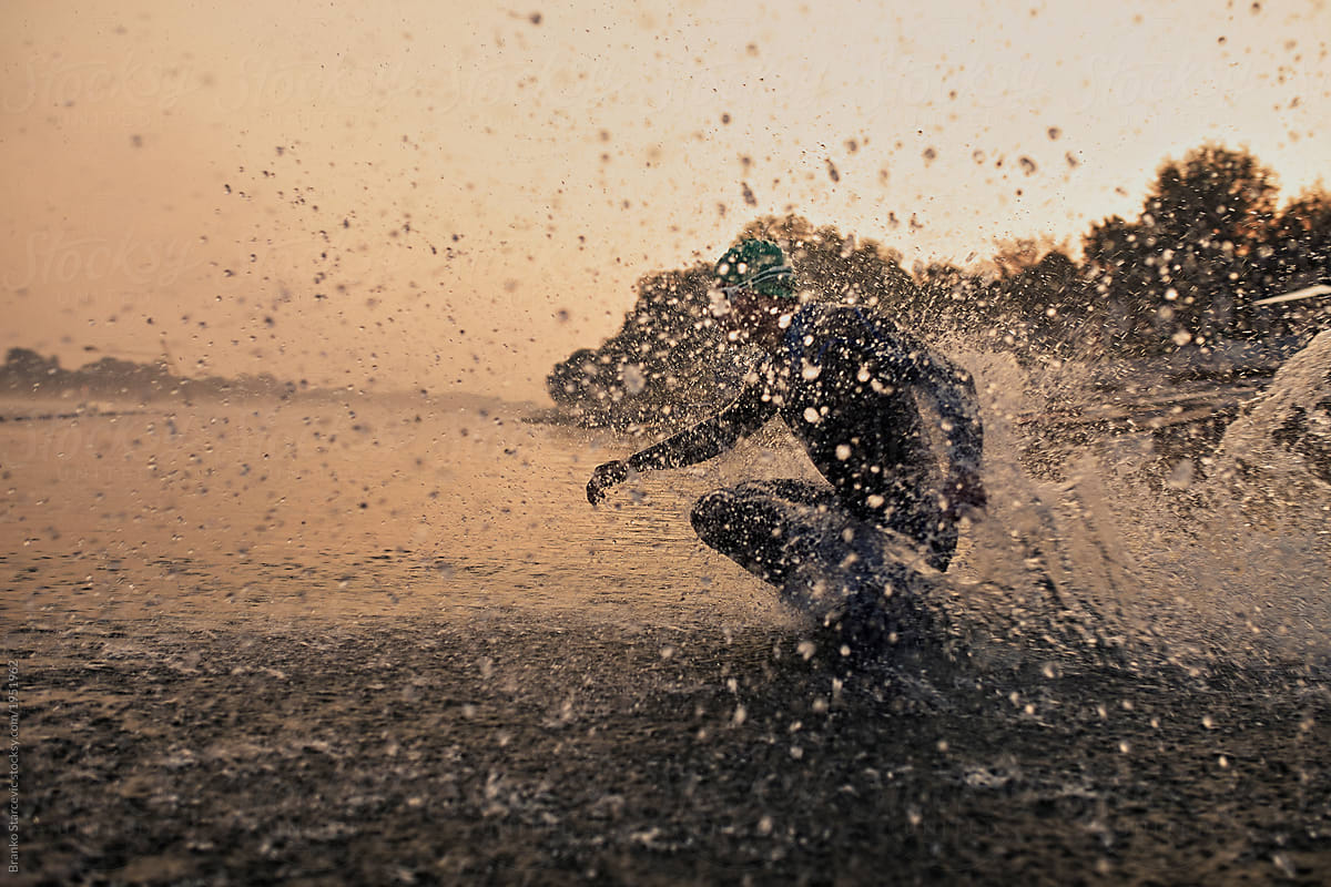 Triathlete running into water.
