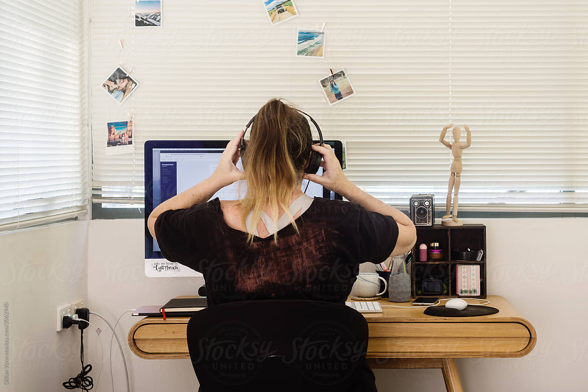 woman using headphones as she works at home