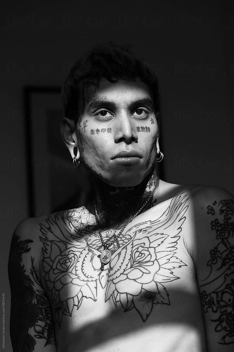 moody young man with face tattoo portrait