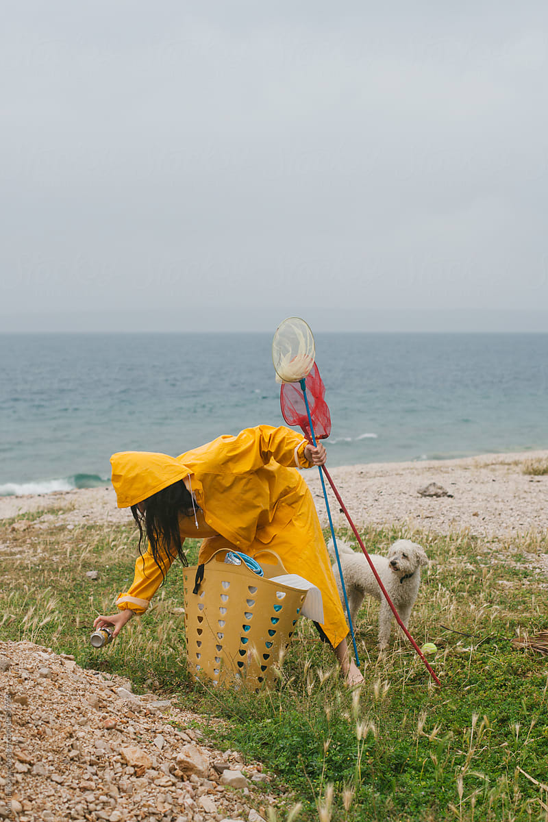 Woman Cleaning Up A Plastic From The Beach by Stocksy Contributor Marija  Kovac - Stocksy