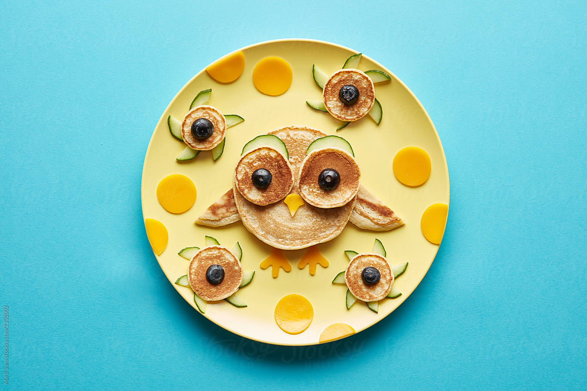 An owl pancake with cucumber and berries.