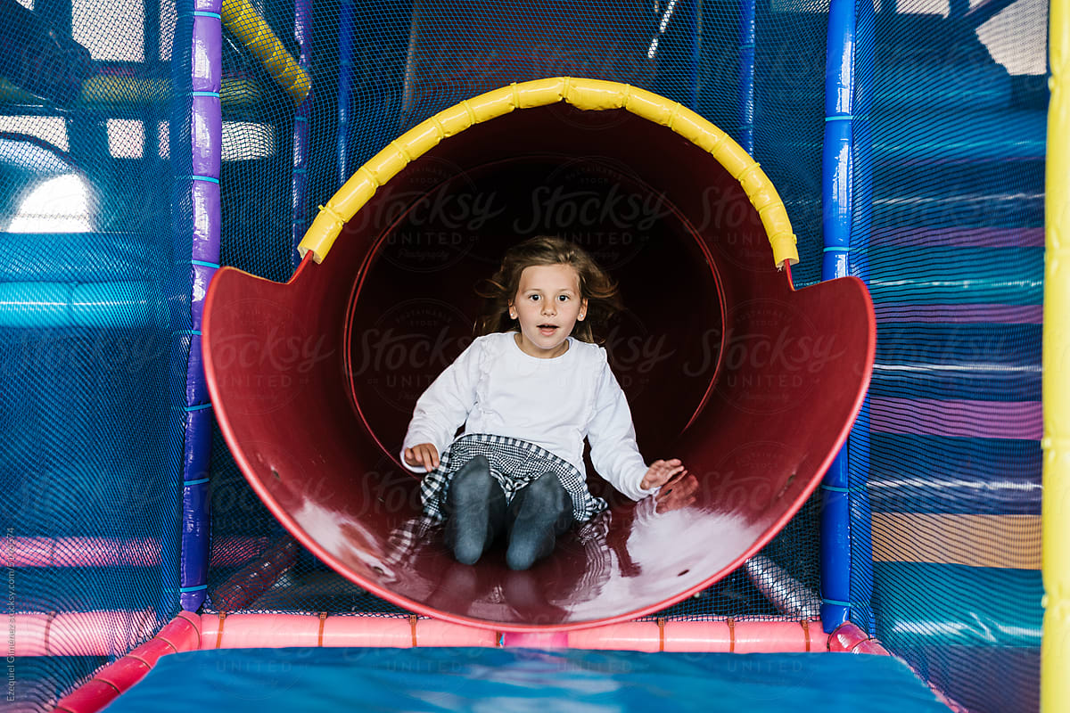Astonished kid riding slide on playground