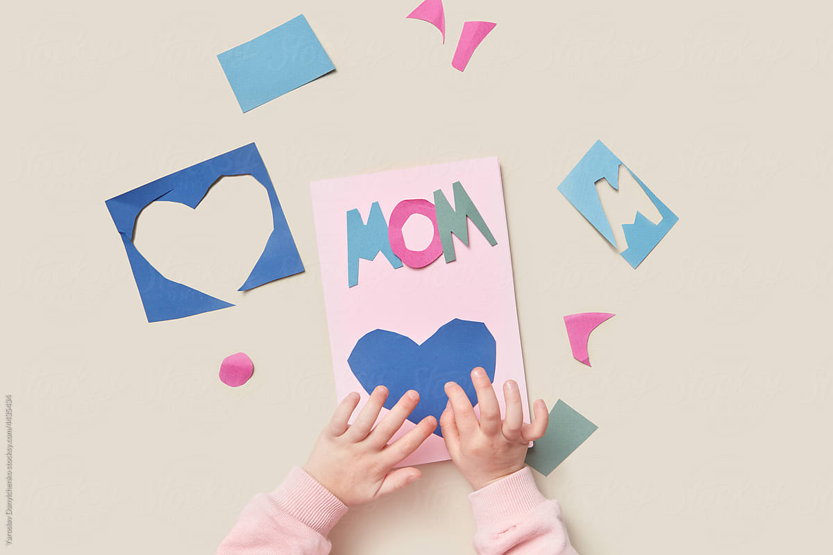 Little kid making papercraft greeting card for mom