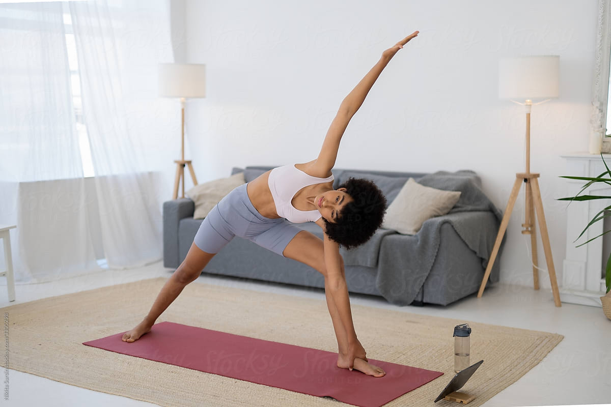 Girl Does Yoga Poses Dog In The Morning In Cozy Living Room by