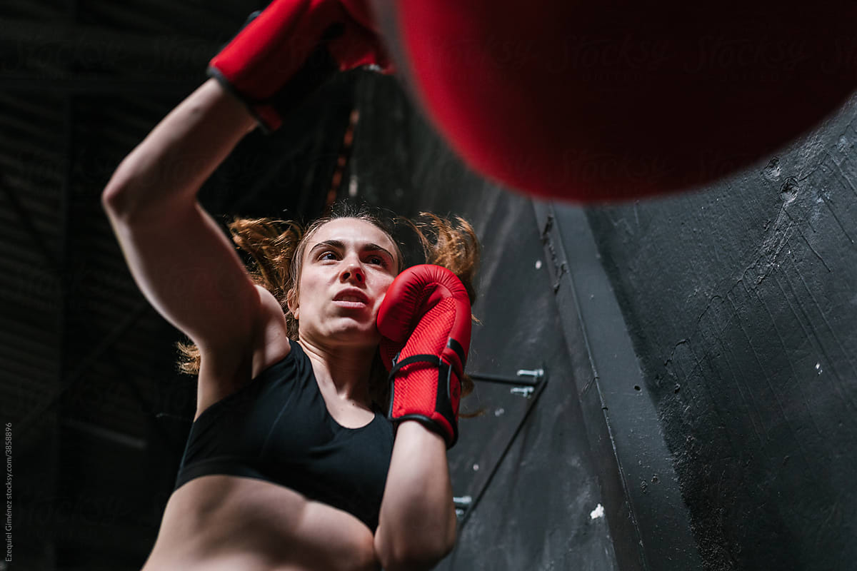 Energetic boxer punching bag in gym