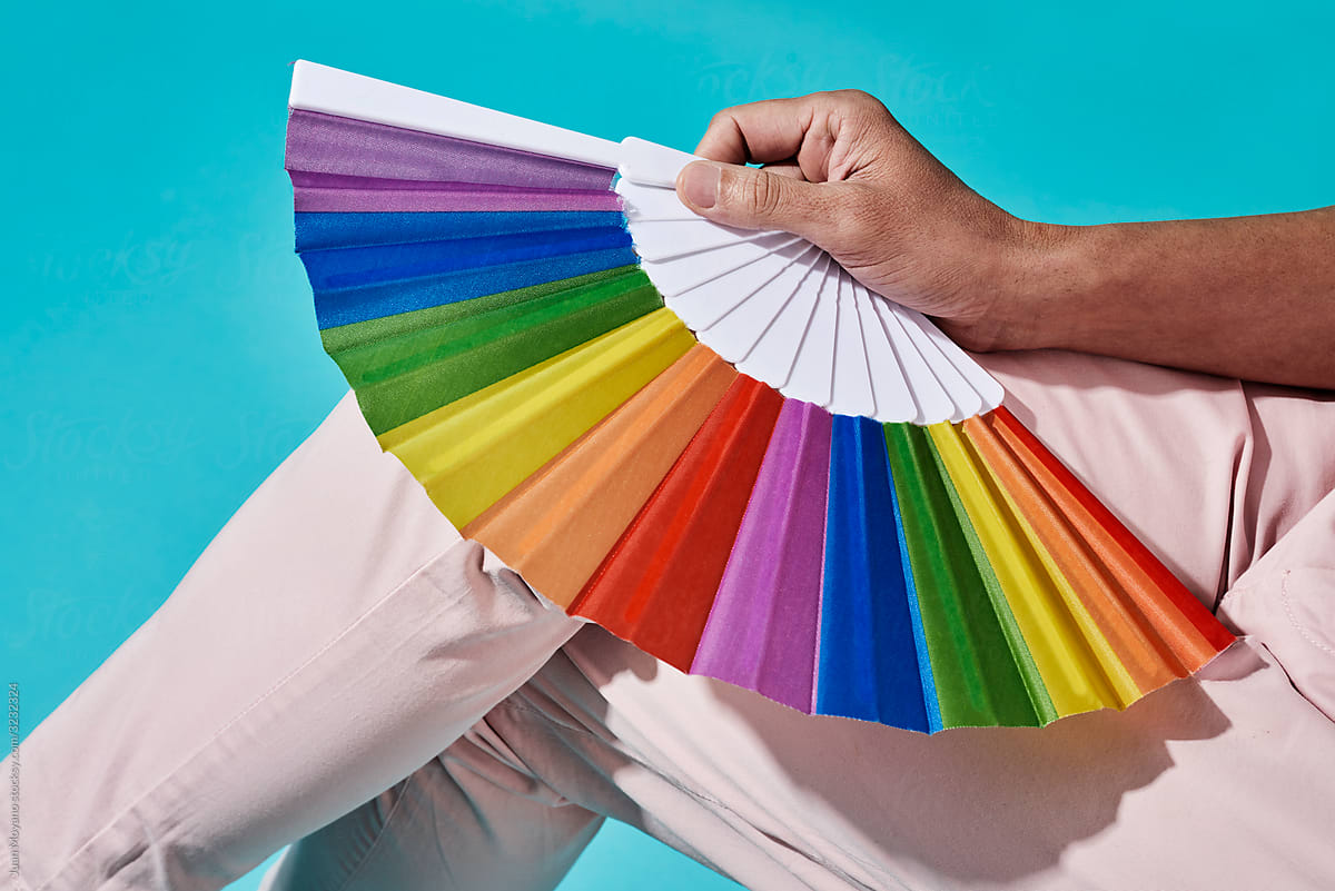 person in pink with a rainbow hand fan