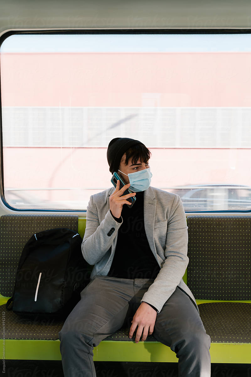 Male passenger speaking on smartphone in train