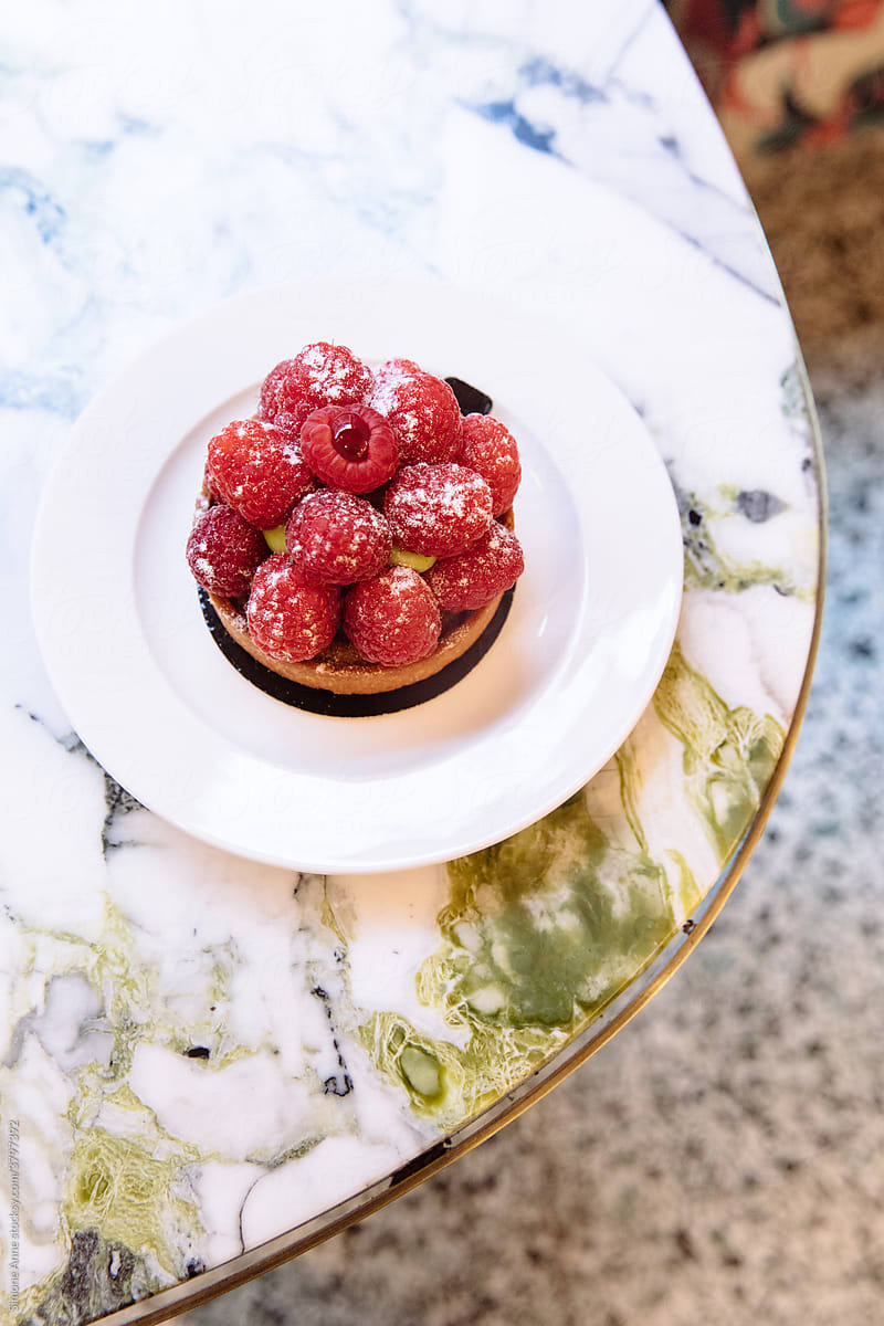 Raspberry Tart sits on a table in a bakery