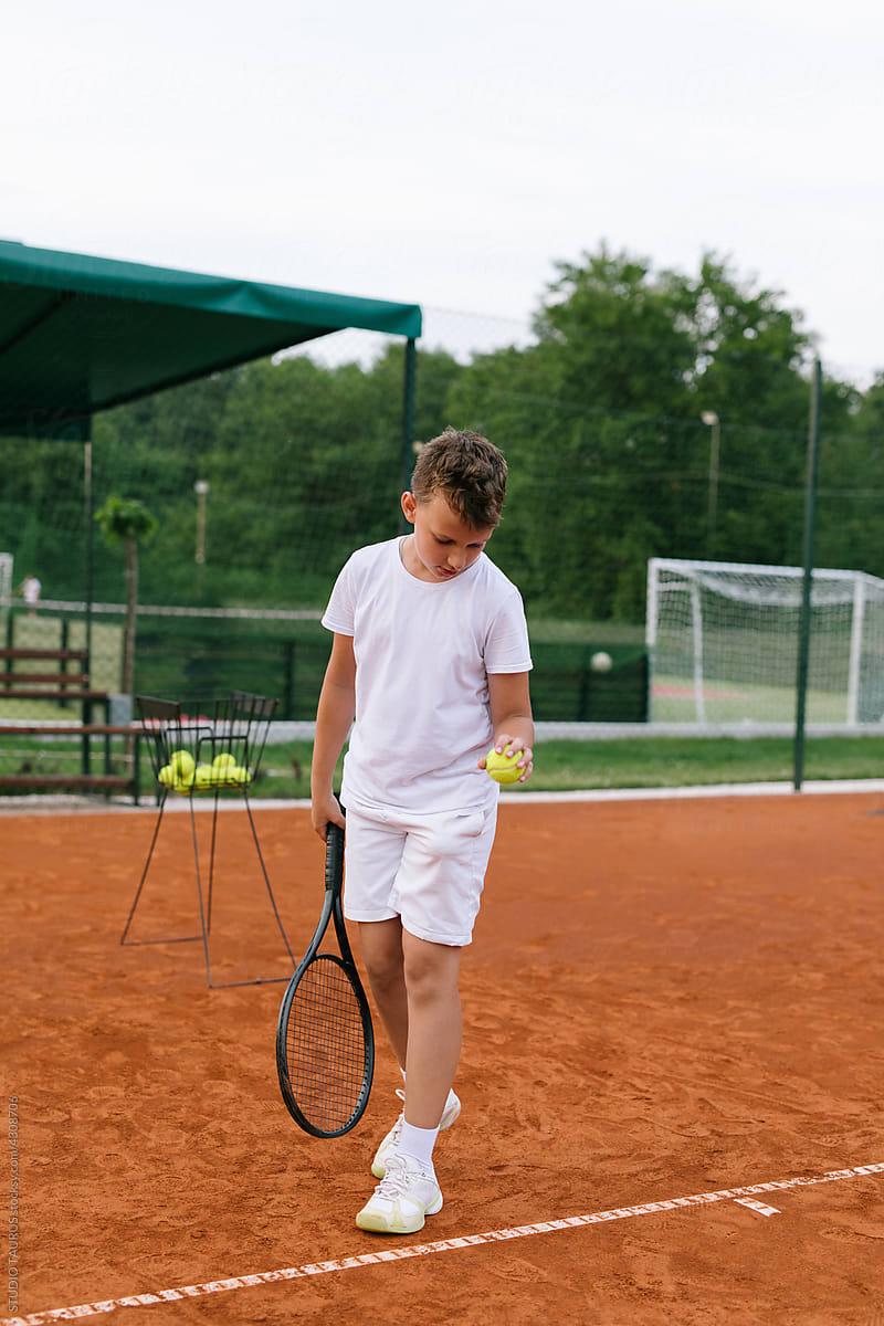 Young boy practicing tennis on the tennis court