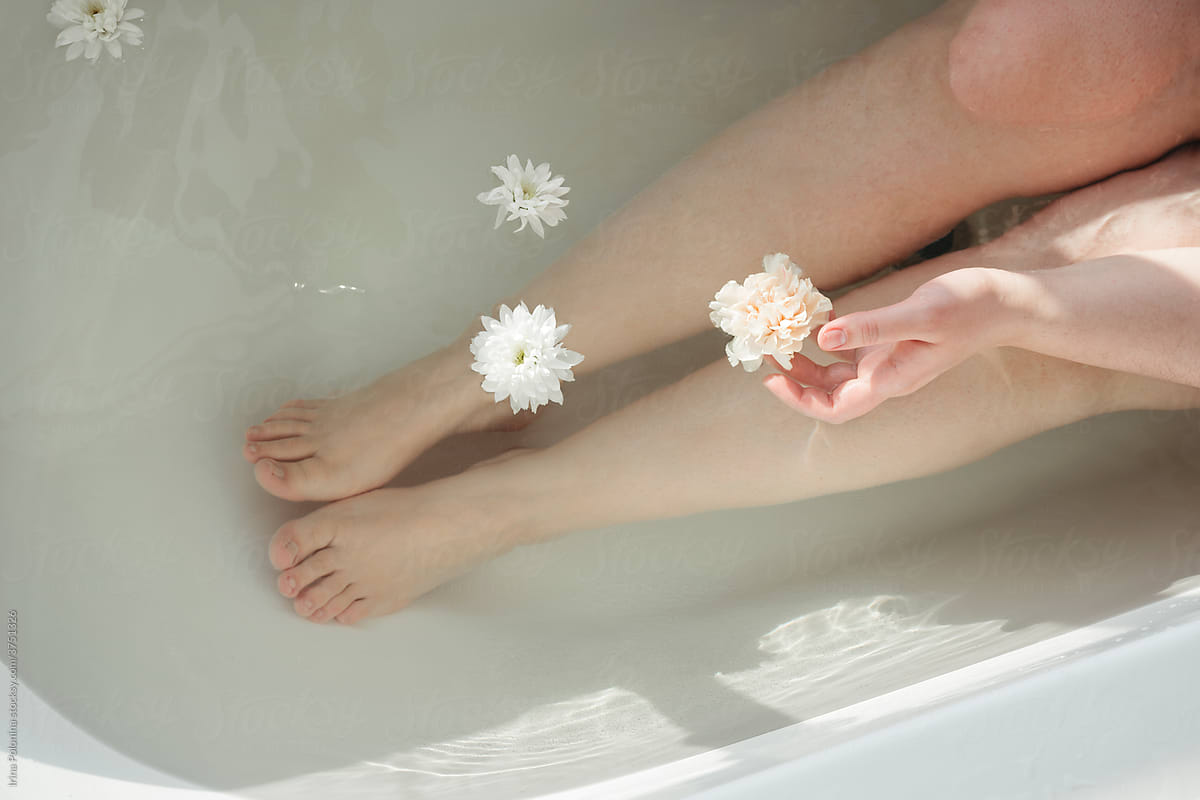 Faceless woman takes bath with flowers.