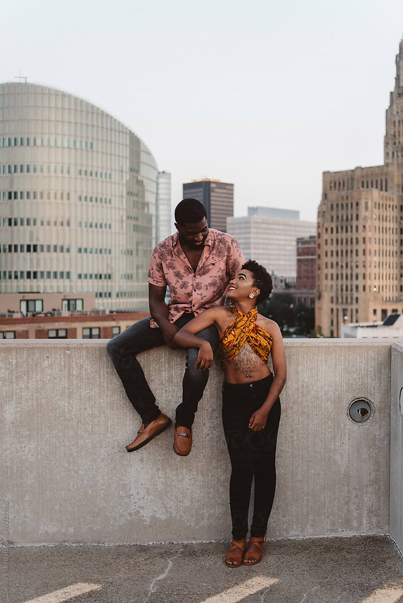 A young black couple watching the sun set in the city
