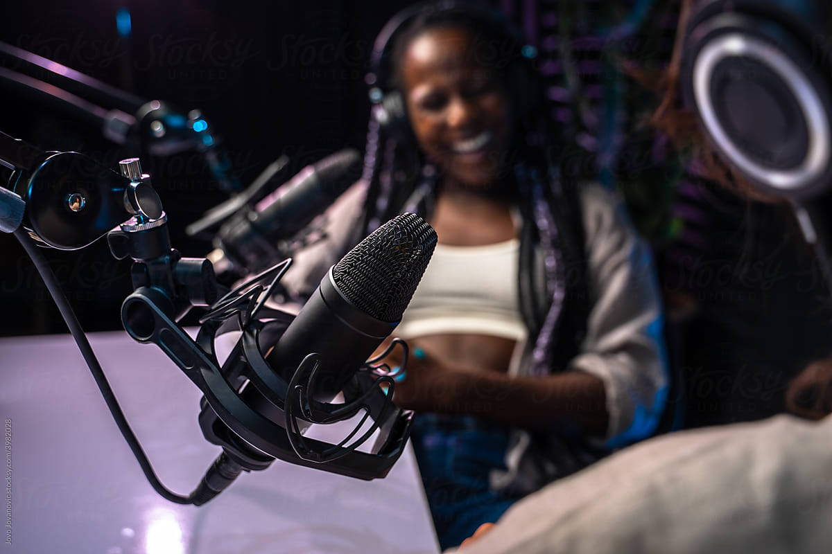 Woman laughing in studio with microphone in focus