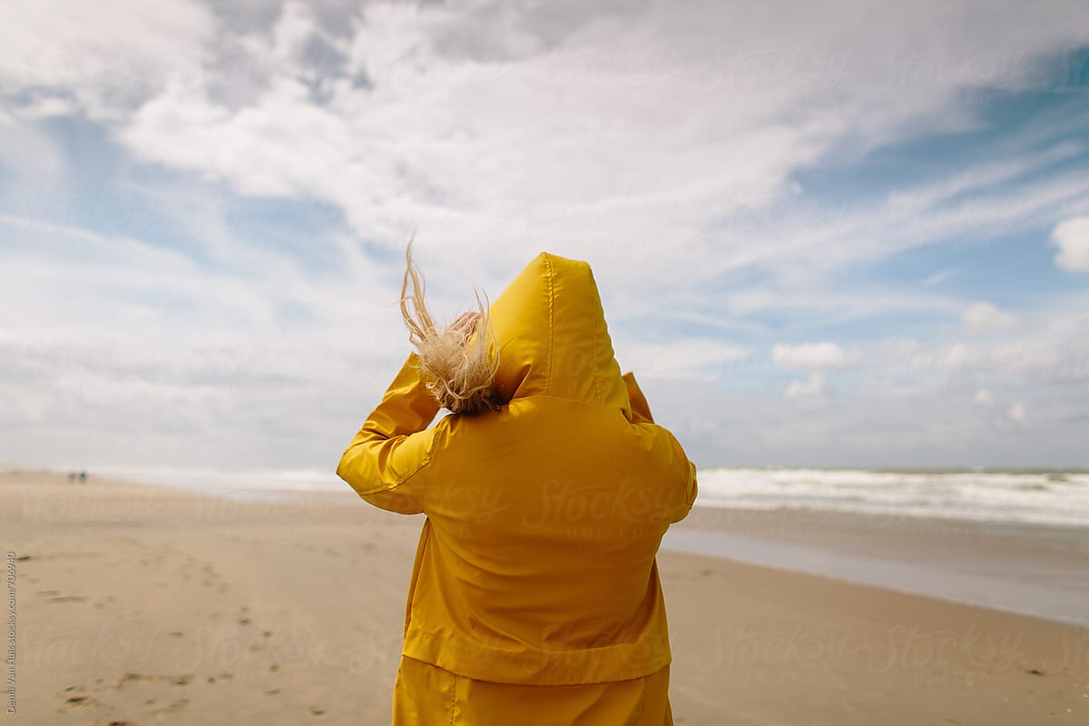 Woman On A Windy Beach Wearing A Yellow Raincoat By Stocksy Contributor Denni Van Huis 3629