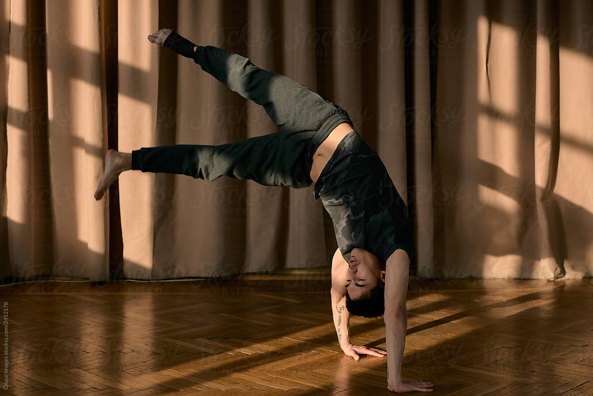 Sportive man in handstand while dancing