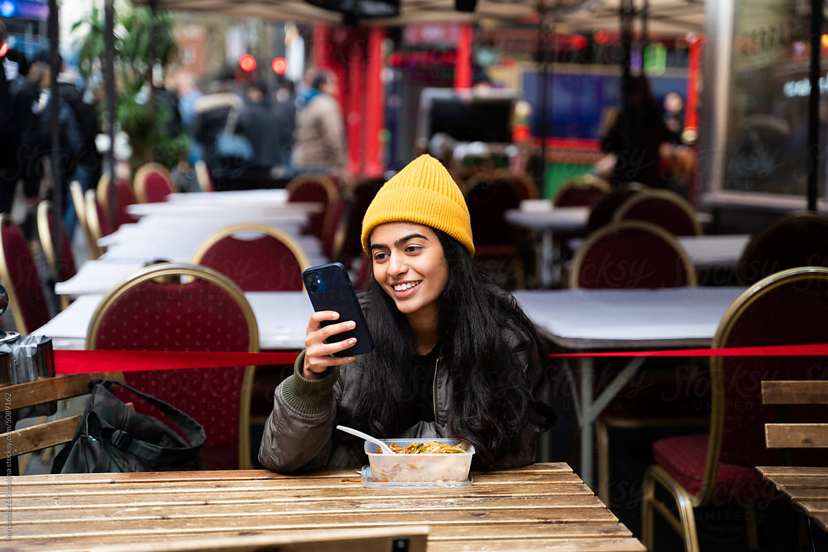 Woman Using Cellphone While Eating