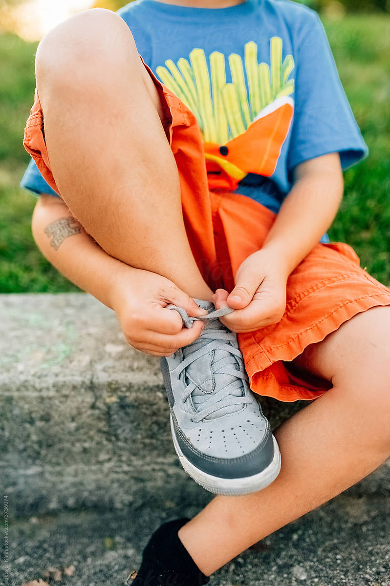 Boy learning to tie shoes.