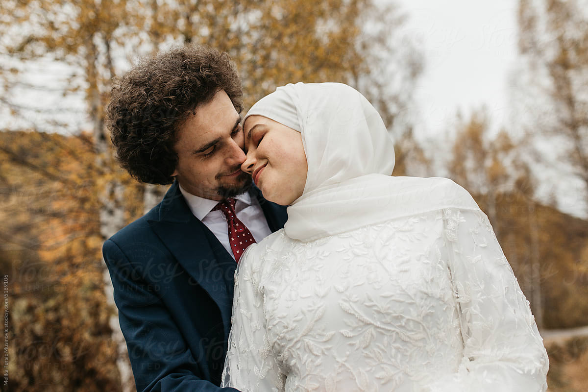 A woman with headscarf leaning on the man shoulder