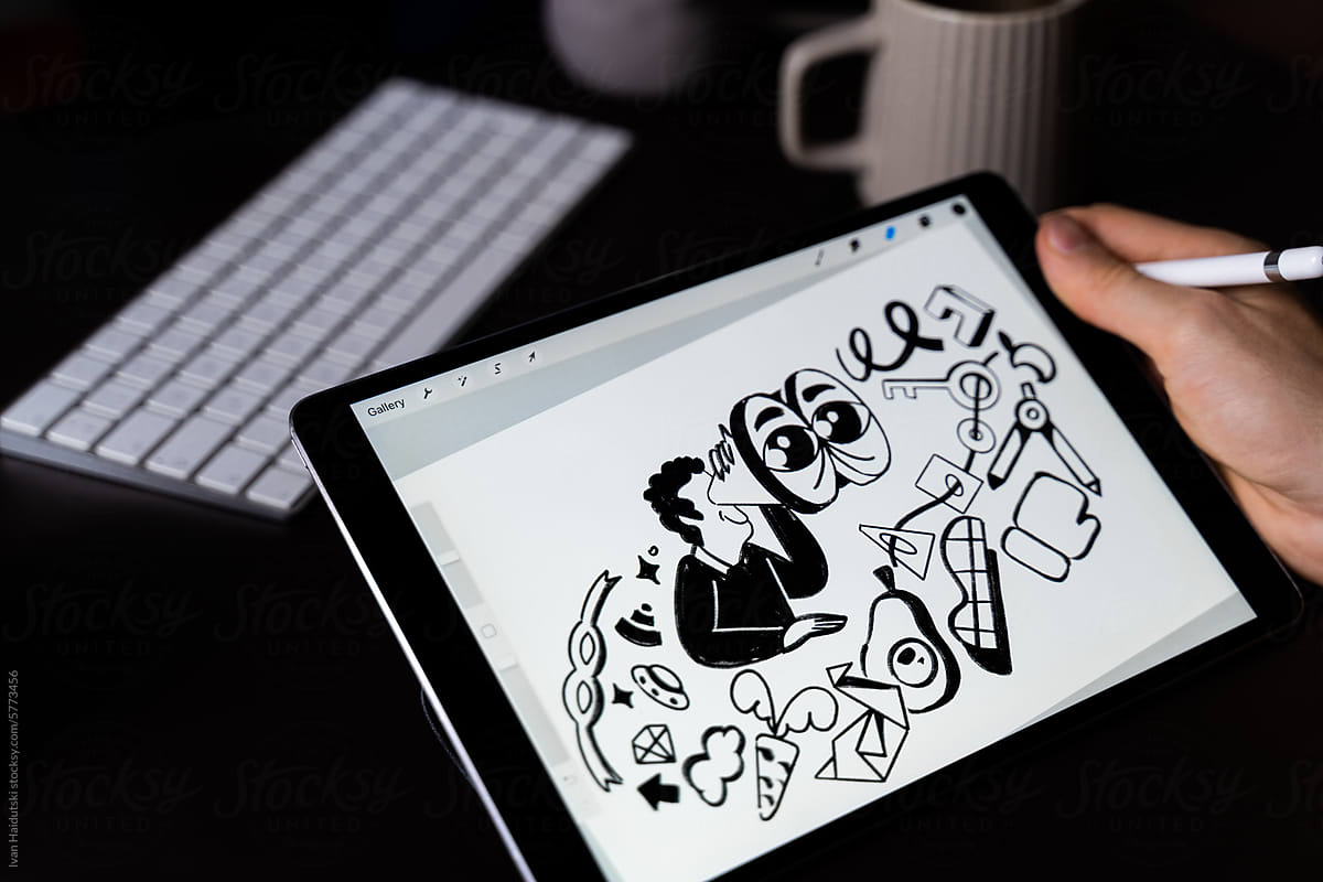 Designer drawing illustration on digital tablet in home workplace