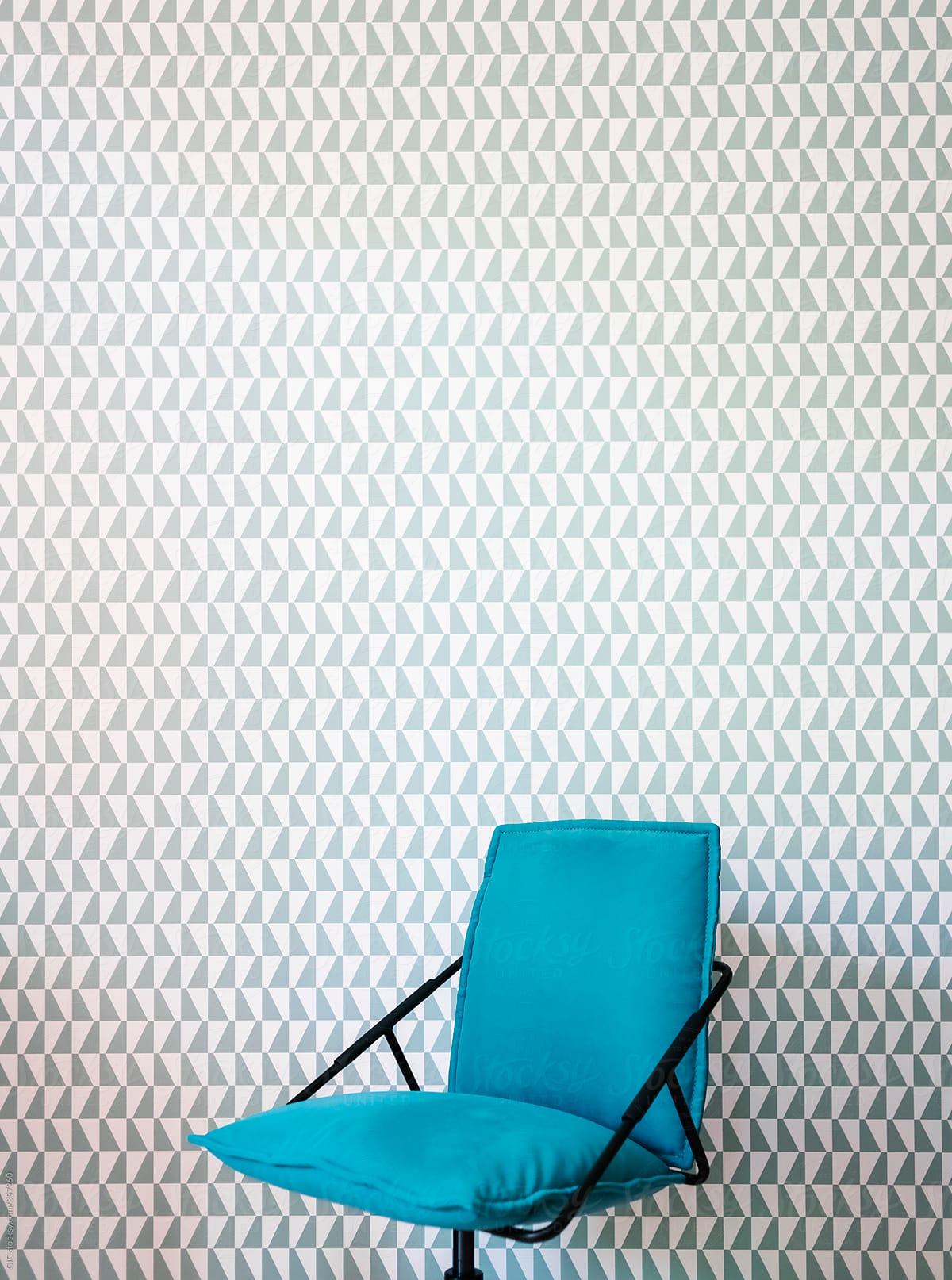 Blue office chair against pattern wallpaper