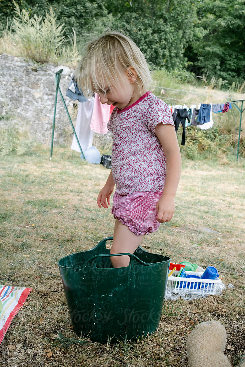 little girl playing with bucket of water