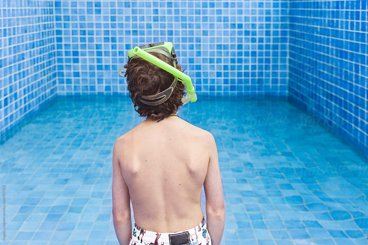 Child standing in empty swimming pool