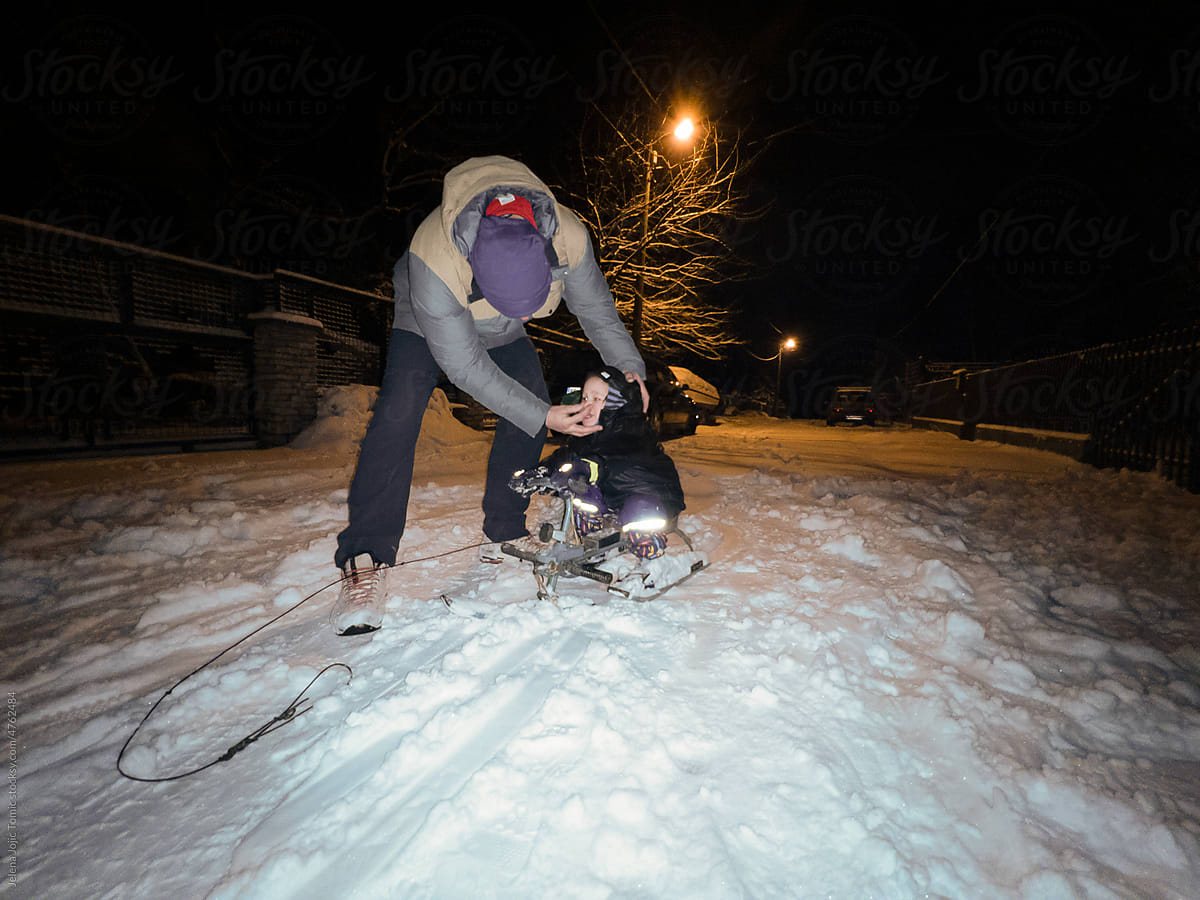 Parent wipes a child\'s nose during the winter, outdoor