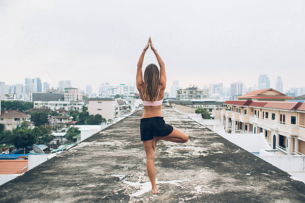 Active Woman Doing Yoga Poses At Roof Of A Urban City by Stocksy  Contributor Dream Lover - Stocksy
