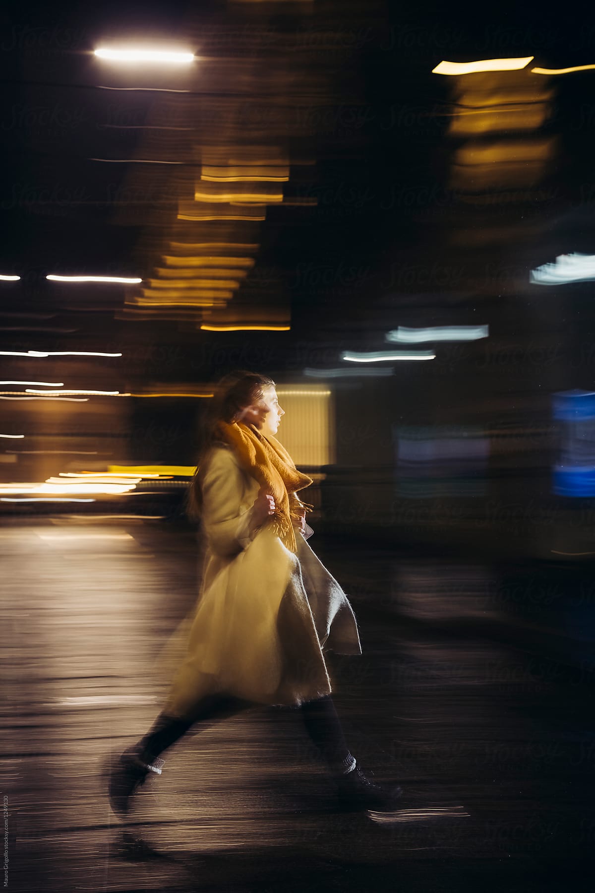 A lonely woman walks fast in the city at night