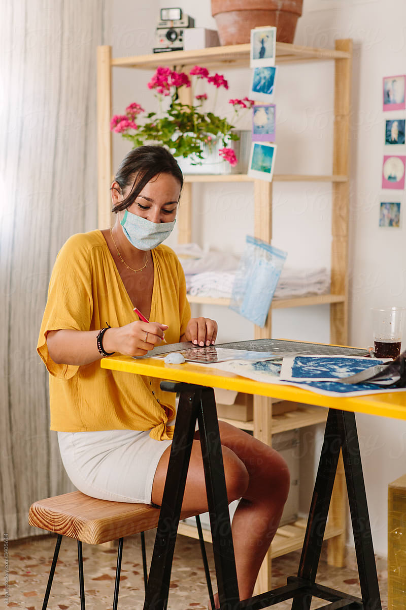 Designer working at desk with facemask