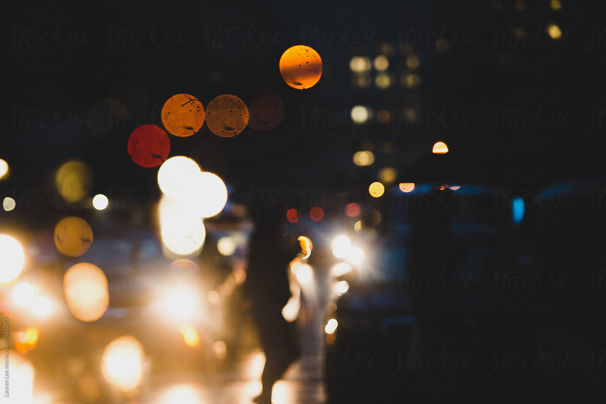 Traffic and people walking in rain at night