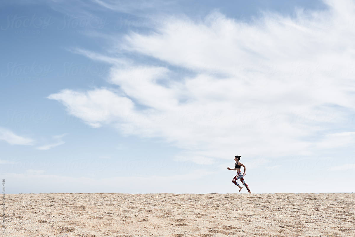 Anonymous woman running on sand