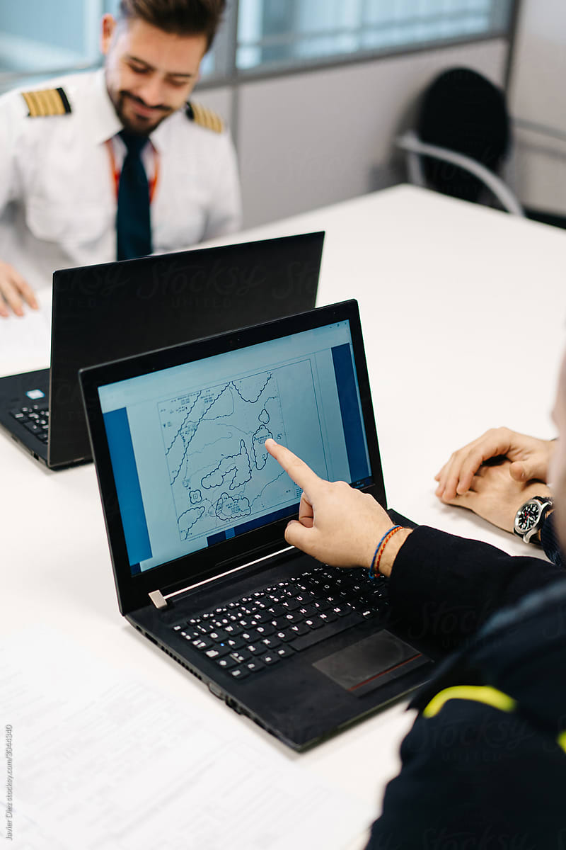 Crop pilots examining  flight path on laptop