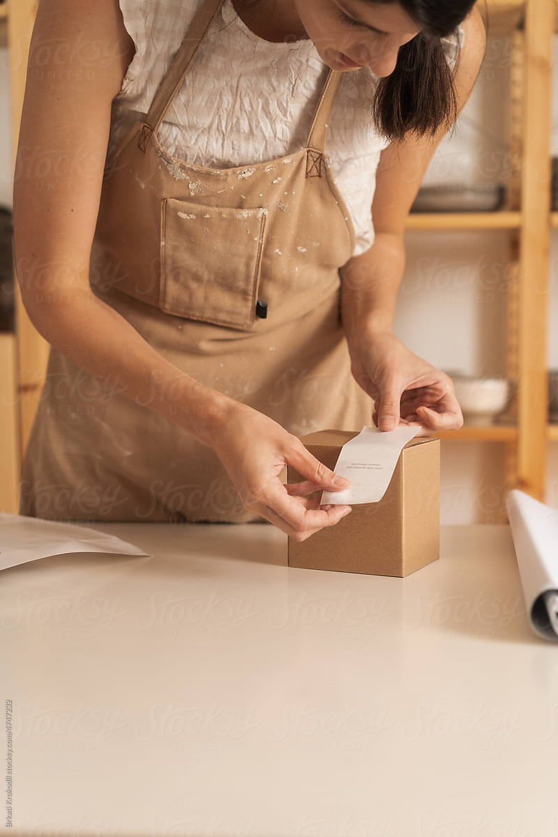 Woman Packing A Product In A Cardboard Gift Box With Sticker Note
