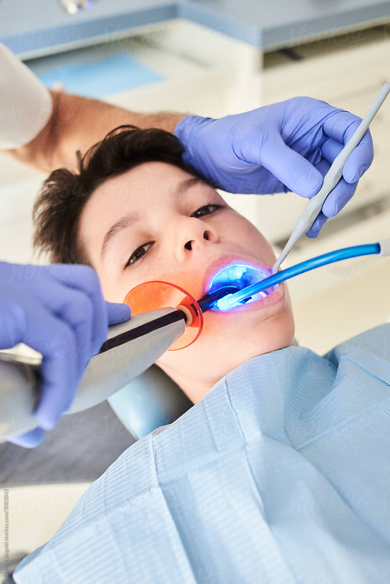 Dentist cleaning boy\'s teeth.