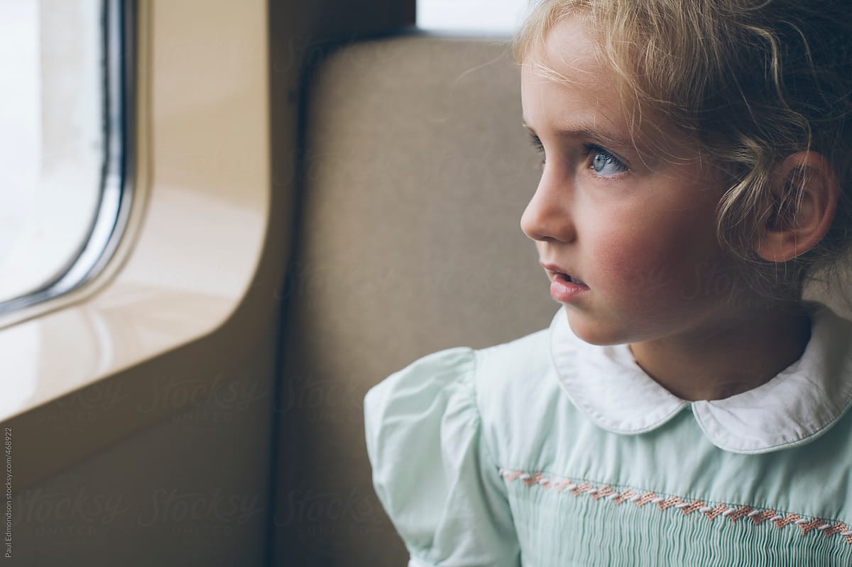 Cute four year old girl looking out ferry window