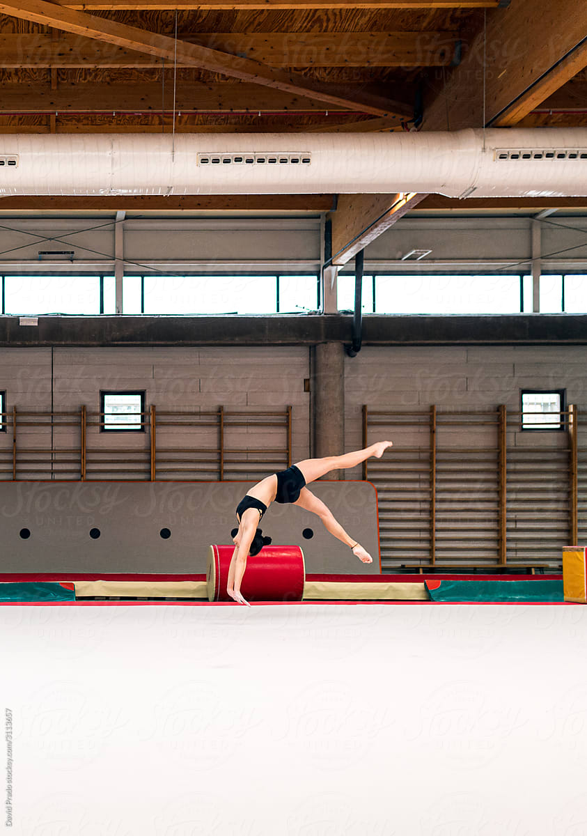 young artistic gymnast woman performing and training somersaults