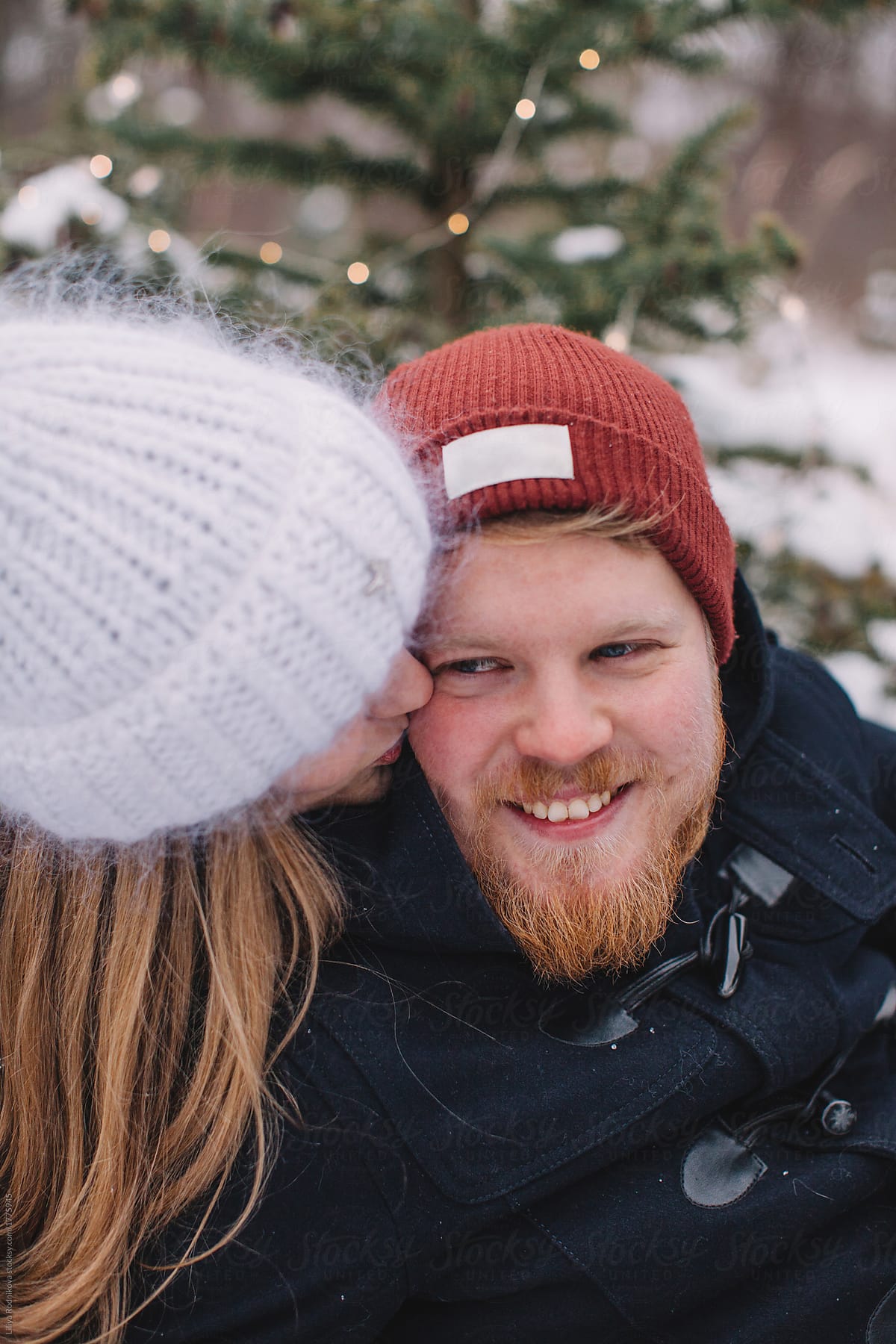 Closeup Portrait Of Cheerful Man And Girlfriend Kissing His Cheek By