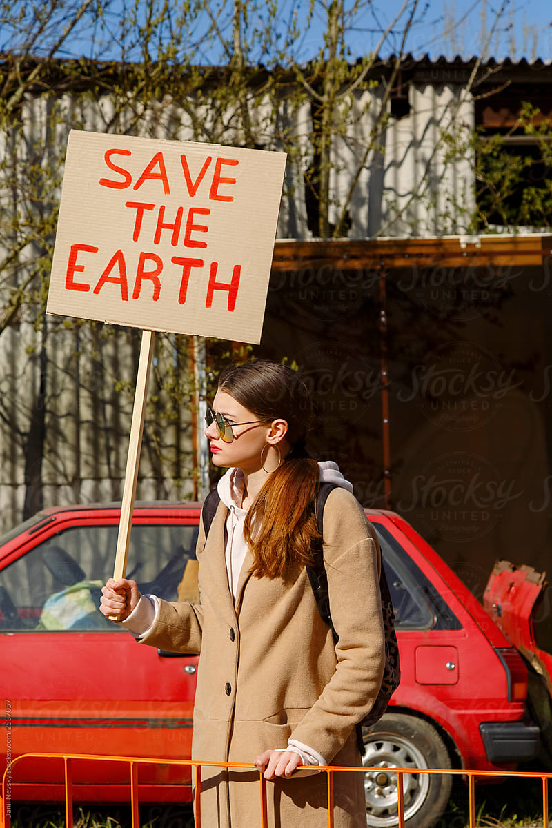 Woman with ecological placard protesting on street