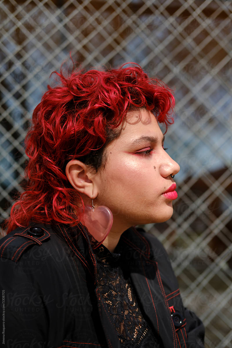 Profile of non-binary person with pierced ear and red hair