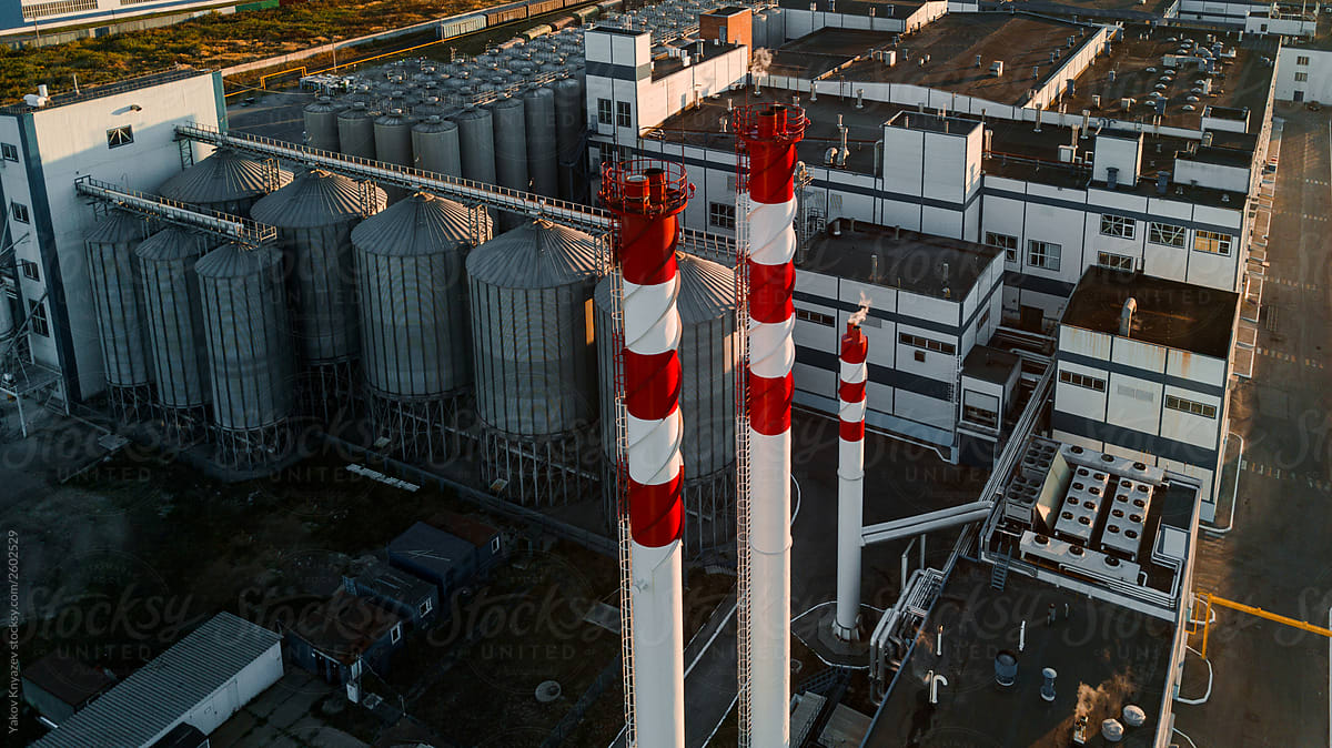 drone shot of a beer factory - tall factory pipes and a set of tanks