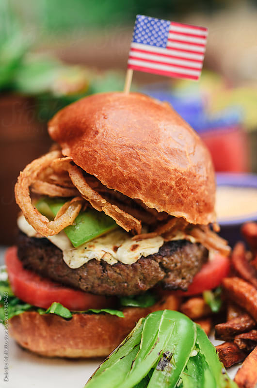 hamburger with onion rings and an american flag