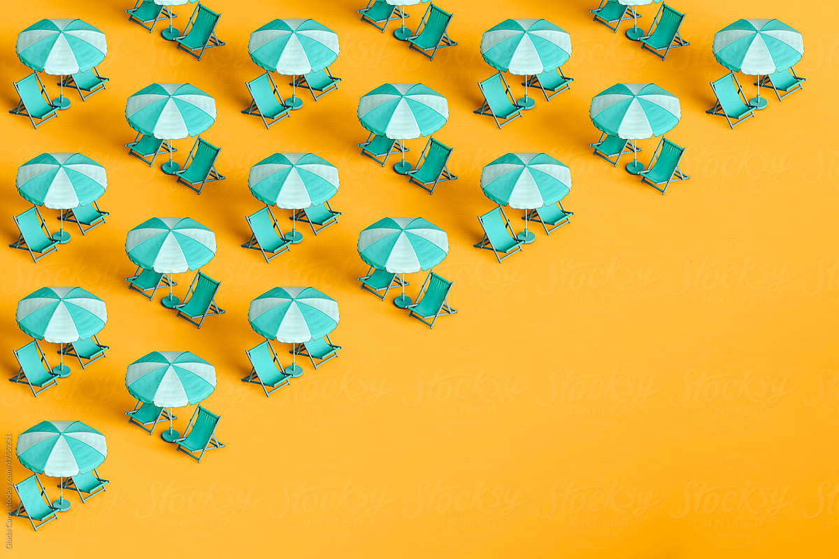 many blue beach umbrellas and chairs on yellow