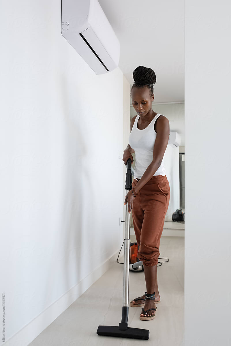 African female cleaning light corridor