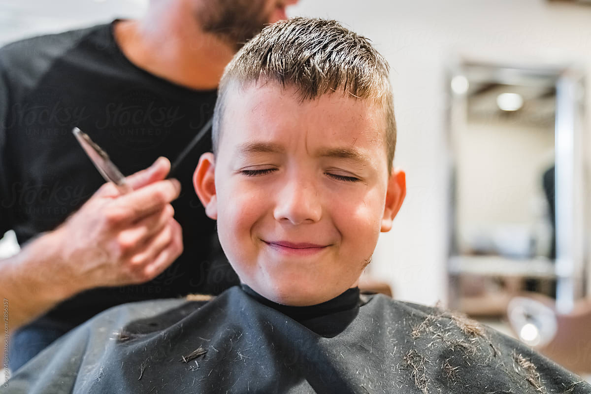 Boy with closed eyes in hairdressing salon